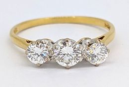 An 18ct gold three stone diamond ring, claw set with three brilliant-cut diamonds, approx. 0.75