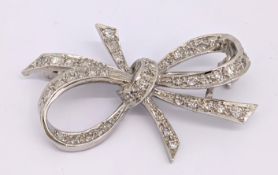 An 18ct gold and diamond bow brooch, grain set with an array of single-cut diamonds, partial