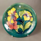 Moorcroft Charger Hibiscus pattern on green ground c1960's designed and signed Walter Moorcroft.