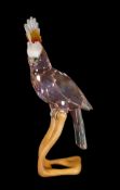 Swarovski Crystal Paradise Cockatoo Red figure mounted on wooden perch, designed by Roland Schuster,