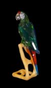 Swarovski Crystal Paradise Macaw (chrome green), mounted on wooden perch, by Roland Schuster, with