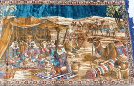 Large brightly coloured rug with tassels depicting a desert scene with Middle East characters and
