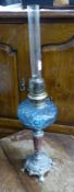 Early 20th century oil lamp with blue glass reservoir, tapering stone column and cast metal base, no