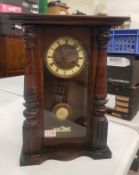 Early 20th century wall hanging mechanical clock, oak cased with column detail to the front, brass