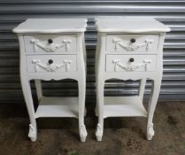 A pair of modern, painted white 2-drawer bedside tables, with lower tier shelf to each, swag and bow
