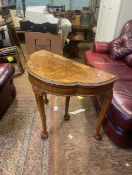 Burr walnut console table that converts to a games/card table, raised on ball and claw feet, card