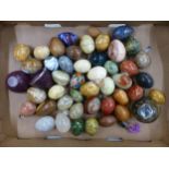 A collection of decorative eggs, agate, soapstone, treen examples, etc (1 tray).