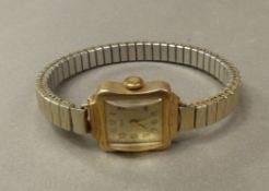 Ladies vintage 9ct gold watch case on a gold plated expanding bracelet.