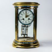 A good quality French 19th century brass and champlevé enamel mantle clock, the case of oval form,