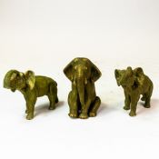 A trio of Royal Dux elephant figures, one seated and two with trunks in salute, height of tallest