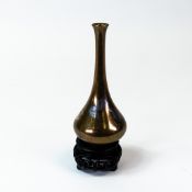 Japanese bronze tear drop shaped vase, decorated with silvered herons, h.13cm, on carved wooden