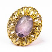 9ct Gold large dress ring, set with oval light purple stone in elaborate gold flower setting, size
