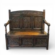 An Edwardian three-panel carved settle with hinged seat, H115cm x W120cm x D44cm.