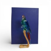 Swarovski Crystal Paradise Macaw (chrome green), mounted on wooden perch, by Roland Schuster, with