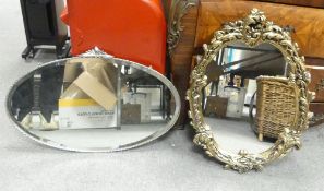 A vintage oval decorative mirror with beaded edge and a decorative top detail, smaller oval wall