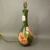Large Moorcroft table lamp in the Hibiscus pattern on green ground, height to top of ceramic 34cm.