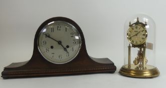 Kundo anniversary clock, with polished brass structure and a rotating pendulum beneath a glass dome,