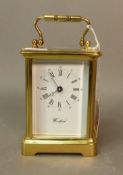 A Woodford brass carriage clock, with visible escapement and loop handle. Working at the time of