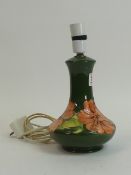 Moorcroft table lamp in the Hibiscus pattern on green ground. (H: 26cm)