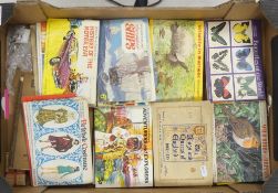 A collection of vintage Brooke Bond tea picture card albums, featuring various themes to include