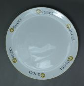 GUCCI: Made in England Gucci plate, white ground with the Gucci black and gold logo repeating around
