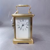 A 20th century gilt brass and bevelled glass cased 'London Clock Co' carriage clock, the white