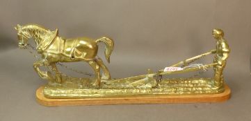 Large brass tableau depicting a heavy horse, plough and ploughman, raised on a plywood base, overall