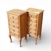 A pair of French Louis XV style oak tallboy cabinets, featuring carved drawer fronts and scrollwork.