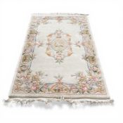Chinese wool rug in sculptured flower design, in pastoral colours with a central medallion, cream