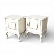 A pair vintage cream - coloured beside cabinets, featuring ornate gold trim, carved details and