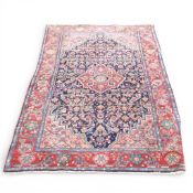 100% Wool Pile rug with recurring floral pattern of reds and navy's (L: 205cm x W: 130cm)