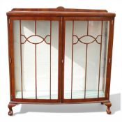 Early 20th century display cabinet featuring bow-fronted glazed doors and claw and ball feet, with