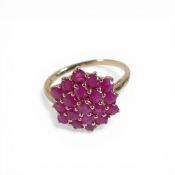 yellow metal ring set with a cluster of red stones, electronically tested to be 9ct gold, size P,