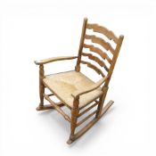 Vintage provincial rocking chair featuring a ladder back design and a rush seat. (H: 87cm) COURIER