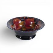 William Moorcroft waisted foot bowl in the Pomegranate pattern on blue ground. (D: 20.5cm)