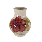 Moorcroft vase in the Hibiscus pattern on cream ground. (H: 25cm)