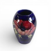 Moorcroft vase in the Anemone pattern on dark blue ground. (H: 14cm)