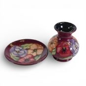 Moorcroft squat vase and pin dish, both in the Pansy pattern on burgundy ground. (H: 9.5cm) (2)