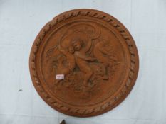 Large terracotta circular wall plaque depicting cherubs riding mythical sea creatures, diameter 55.