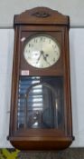 Oak cased mechanical wall clock, pendulum present.