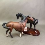 Beswick horse figures, a matt brown Swishtail horse, together with Black Beauty on a wooden
