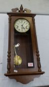 An oak cased Hermle wall clock, pendulum and key present.