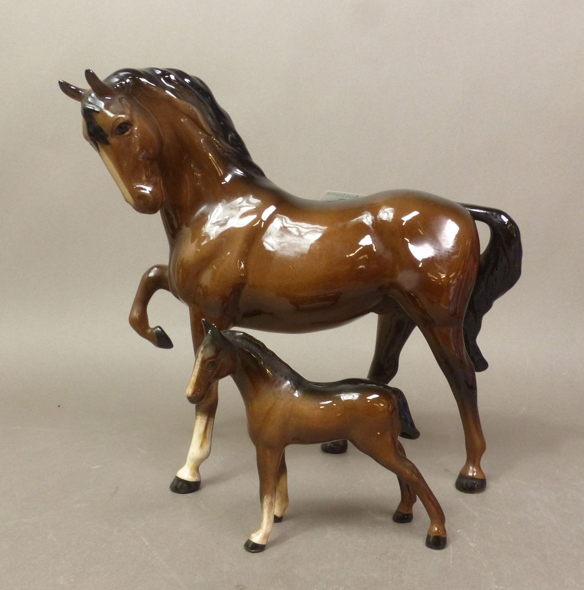 Beswick, bay horse, head tucked, leg up, model no.1549 and Thoroughbred foal, model no.1816. (2)