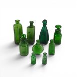 A collection of vintage green poison and apothecary bottles of various shapes and sizes, some with