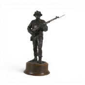 A collectible cold-bronze resin sculpture depicting a British Army soldier holding a rifle, on