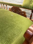 A Victorian antique oak chaise longue sofa featuring green velvet upholstery with carved wood