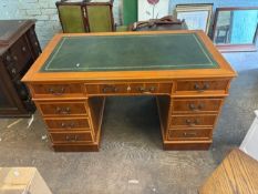 A reproduction Yew Wood pedestal desk with green leather top and gold tooling. 137cm W x 77cm D x 79