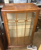 A 1930s Art Deco walnut display cabinet with curved front and interior glass shelving. 68cm W x