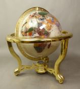 Large inlaid gemstone terrestrial globe on a brass tripod base with integral compass, height 34cm.