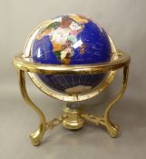 Large inlaid gemstone terrestrial globe on a brass tripod base with integral compass, height 34cm.